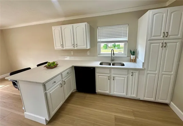 a kitchen with white cabinets and sink