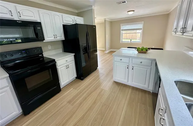 a kitchen with stainless steel appliances a stove microwave and refrigerator