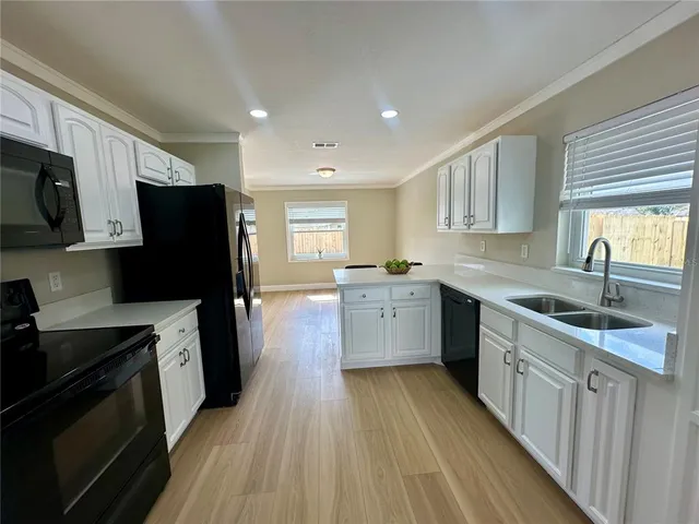 a kitchen with a sink a counter top space stainless steel appliances and cabinets