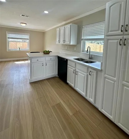 a kitchen with stainless steel appliances granite countertop a sink a stove cabinets and wooden floor