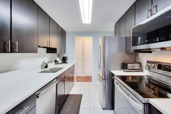 a kitchen with stainless steel appliances granite countertop a sink stove and refrigerator