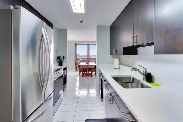 a kitchen with granite countertop a refrigerator and a sink
