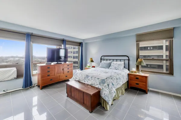 a bedroom with a bed and a large window