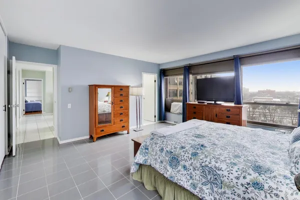 a spacious bedroom with a bed and a large window