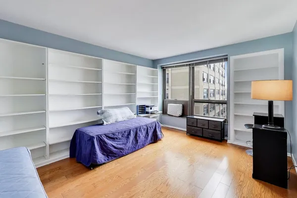 a bedroom with a bed windows and a table