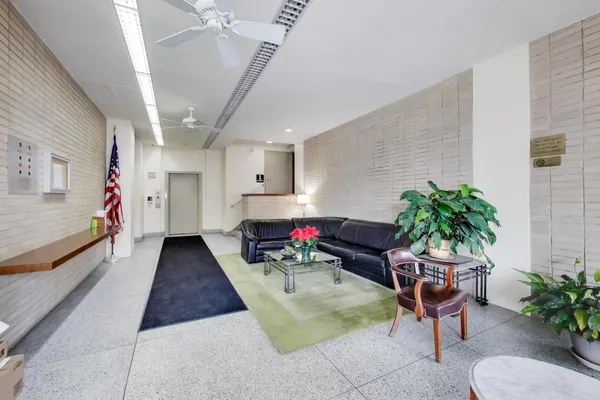 a living room with furniture and potted plants