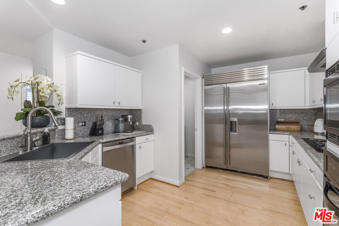 10724 Wilshire Boulevard, Unit 1005 Los Angeles, CA 90024 - Photo 15 of 45 a kitchen with stainless steel appliances granite countertop a sink stove and refrigerator