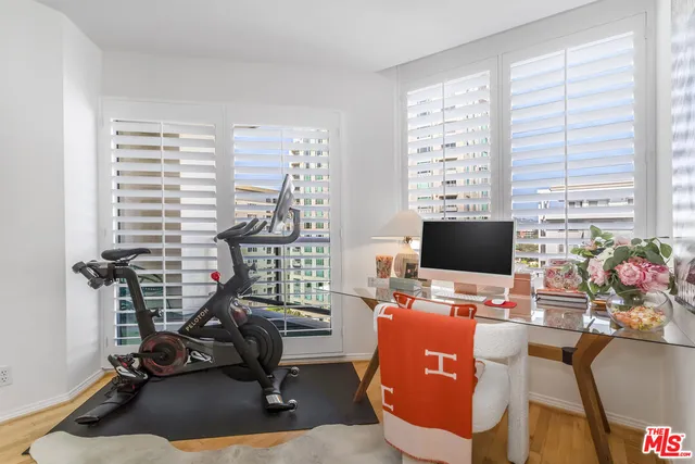 a view of a workspace with furniture and a window