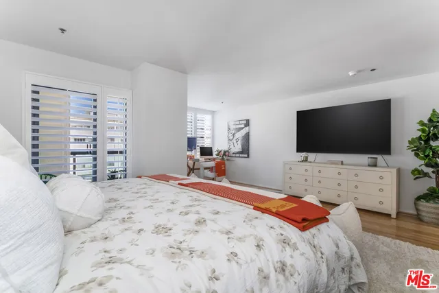 a bedroom with a flat screen television and a bed