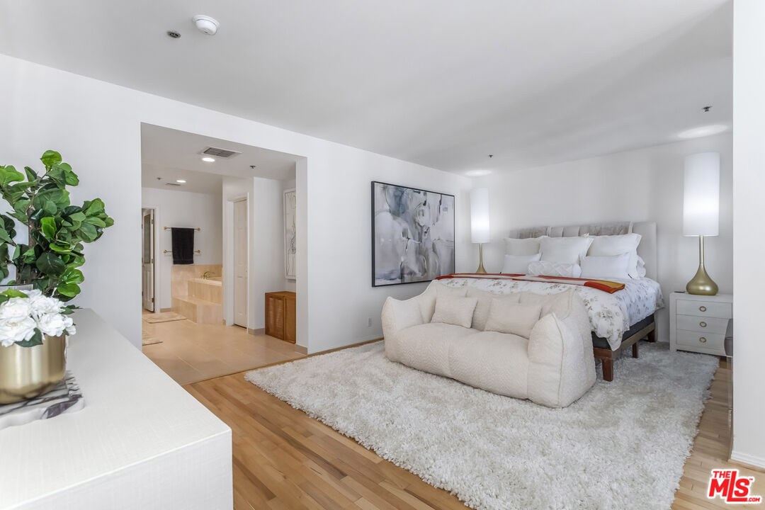 10724 Wilshire Boulevard, Unit 1005 Los Angeles, CA 90024 - Photo 25 of 45 a spacious bedroom with a bed and a potted plant
