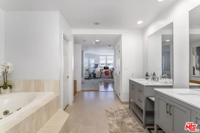 a bathroom with a tub sink and mirror