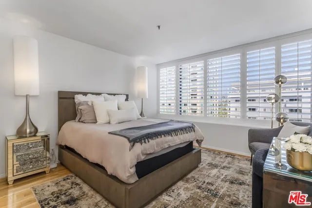 a large bed sitting in a bedroom next to a window