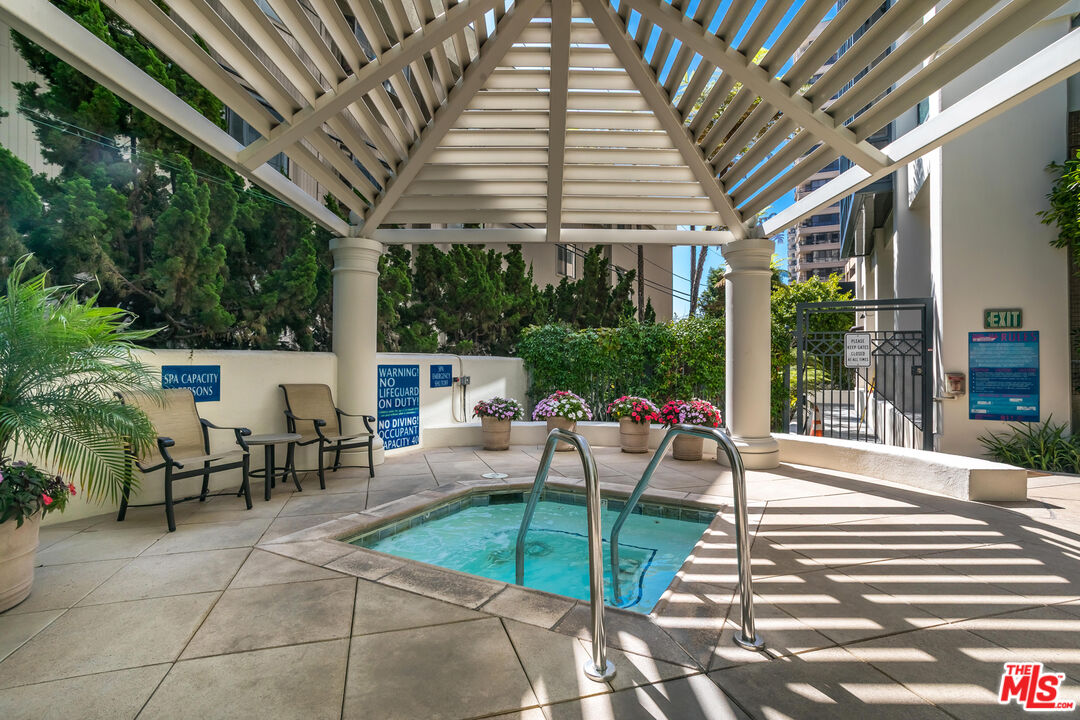 10724 Wilshire Boulevard, Unit 1005 Los Angeles, CA 90024 - Photo 41 of 45 a view of a patio with table and chairs potted plants and large tree