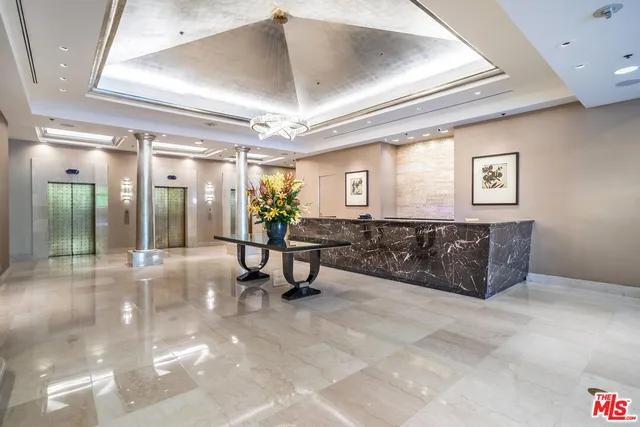 a living room with couches and a chandelier