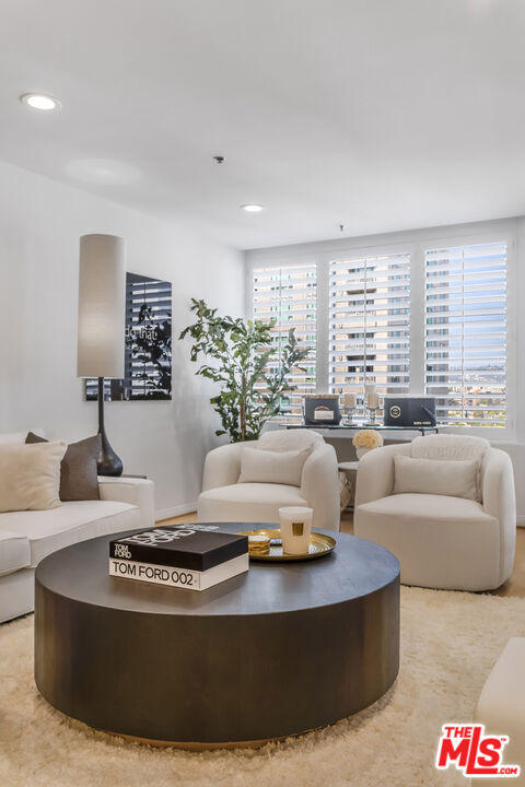 10724 Wilshire Boulevard, Unit 1005 Los Angeles, CA 90024 - Photo 8 of 45 a living room with furniture and large windows