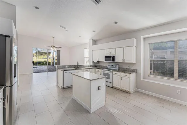 a kitchen with granite countertop white cabinets and white appliances