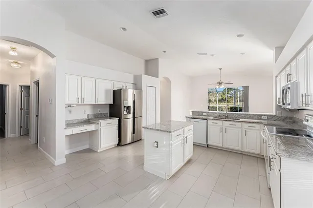 a large kitchen with white cabinets and stainless steel appliances