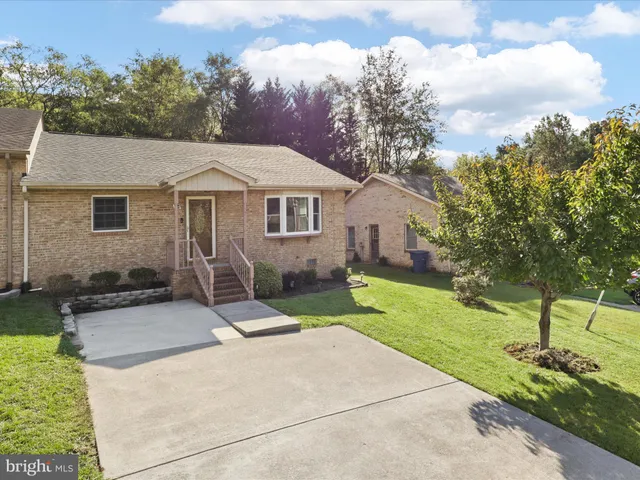 a front view of a house with a yard and trees