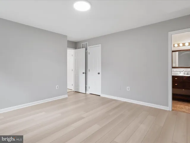 a view of an empty room with closet and a window