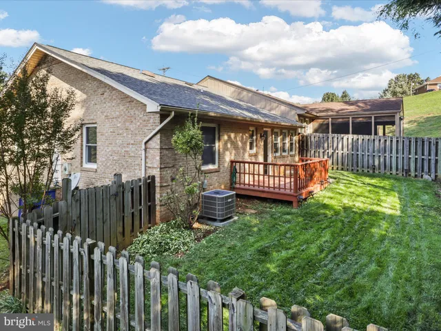 a view of a house with wooden fence and a porch