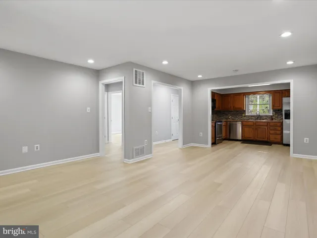 a view of empty room with a kitchen