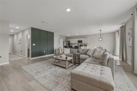 a kitchen with stainless steel appliances a dining table chairs stove refrigerator and cabinets