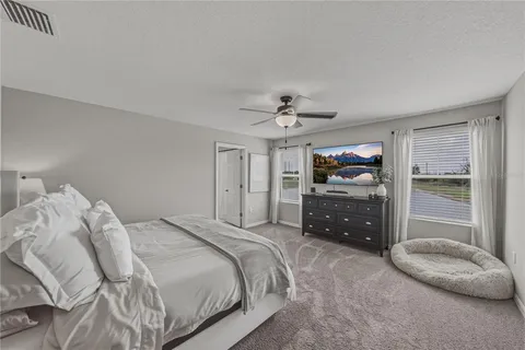 a bedroom with a large bed and a chandelier
