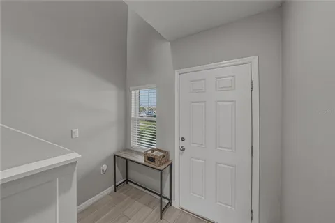 a view of a hallway with chairs and a refrigerator