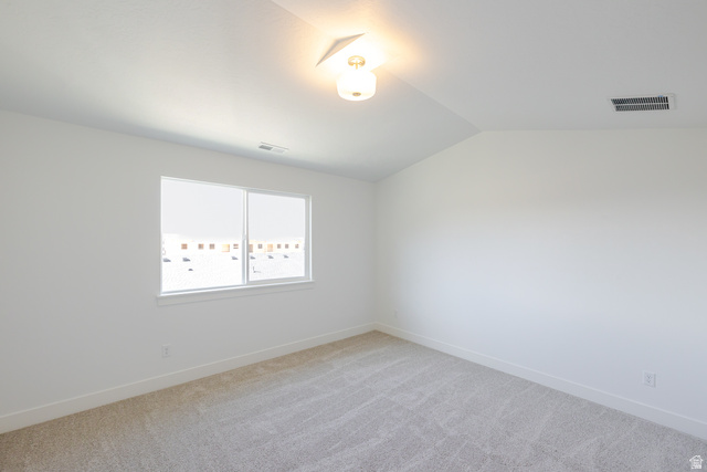 4720 Heartwood Road, Unit 438 Mapleton, UT 84664 - Photo 12 of 19 Spare room featuring light colored carpet and vaulted ceiling