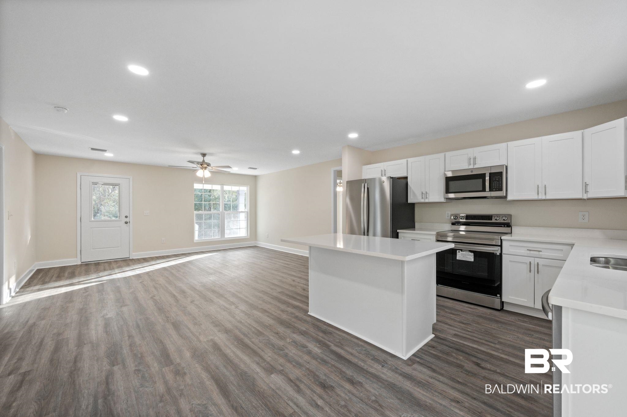 1473 Pollard Road Daphne, AL 36526 - Photo 10 of 32 Kitchen featuring white cabinetry, a center island, appliances with stainless steel finishes, dark hardwood / wood-style floors, and ceiling fan