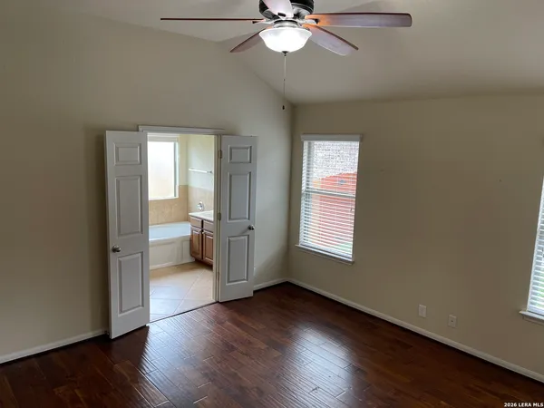 a view of a livingroom with wooden floor and a ceiling fan