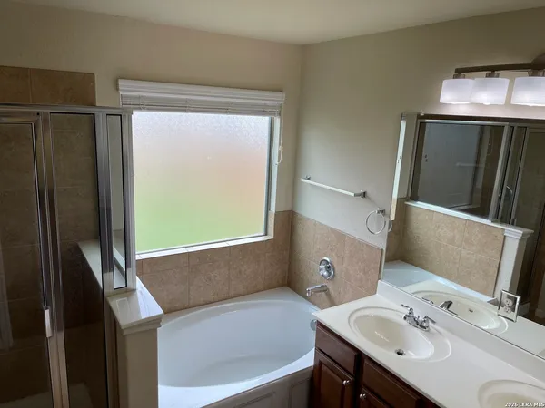 a bathroom with a bathtub a sink and a window