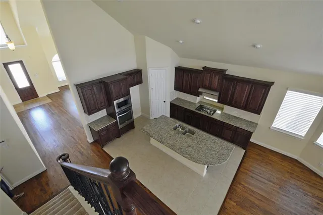 a kitchen with kitchen island granite countertop wooden cabinets a granite counter and a sink