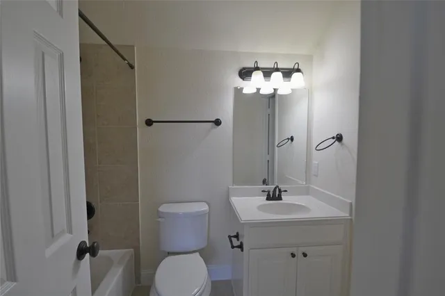 a bathroom with a granite countertop toilet a sink and a mirror
