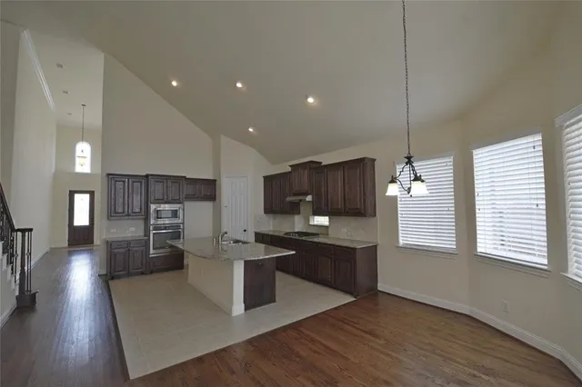 a view of a living room with wooden floor and a ceiling fan