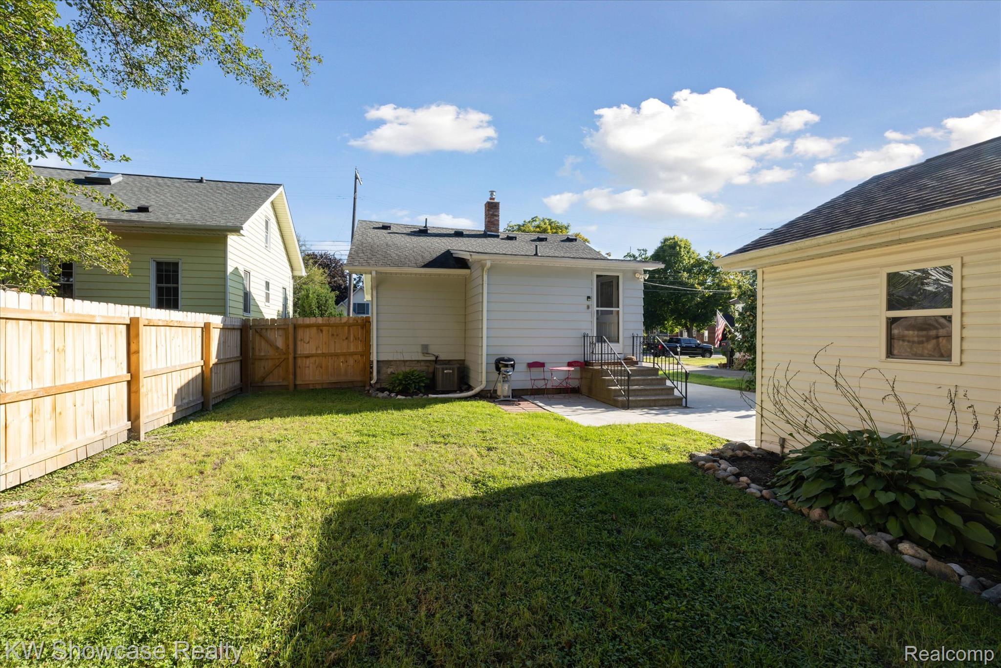 603 West Clinton Street Howell, MI 48843 - Photo 23 of 25 Back of property with a patio area, a chimney, and a fenced backyard