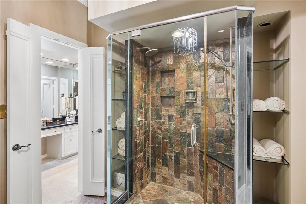 7276 Lupton Circle Dallas, TX 75225 - Photo 26 of 40 a bathroom with a glass shower door and a mirror