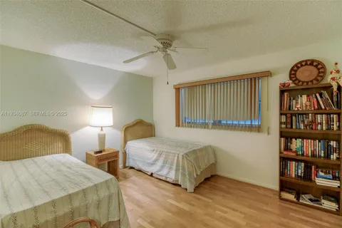 a bedroom with two bed and a book shelf
