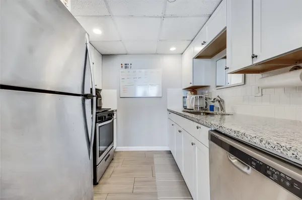 a kitchen with a refrigerator and a stove top oven