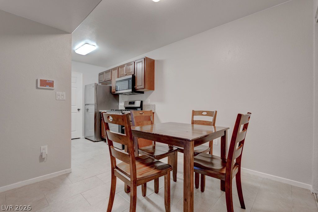 7885 West Flamingo Road, Unit 1016 Las Vegas, NV 89147 - Photo 7 of 24 Functional kitchen and dining area with modern appliances and durable tile flooring.