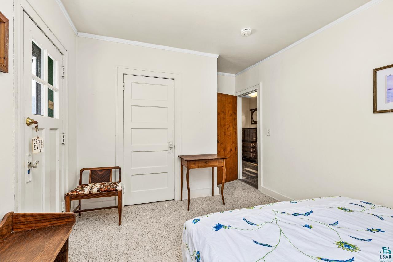 2170 Lester River Road Duluth, MN 55804 - Photo 51 of 66 Bedroom with ornamental molding and light carpet