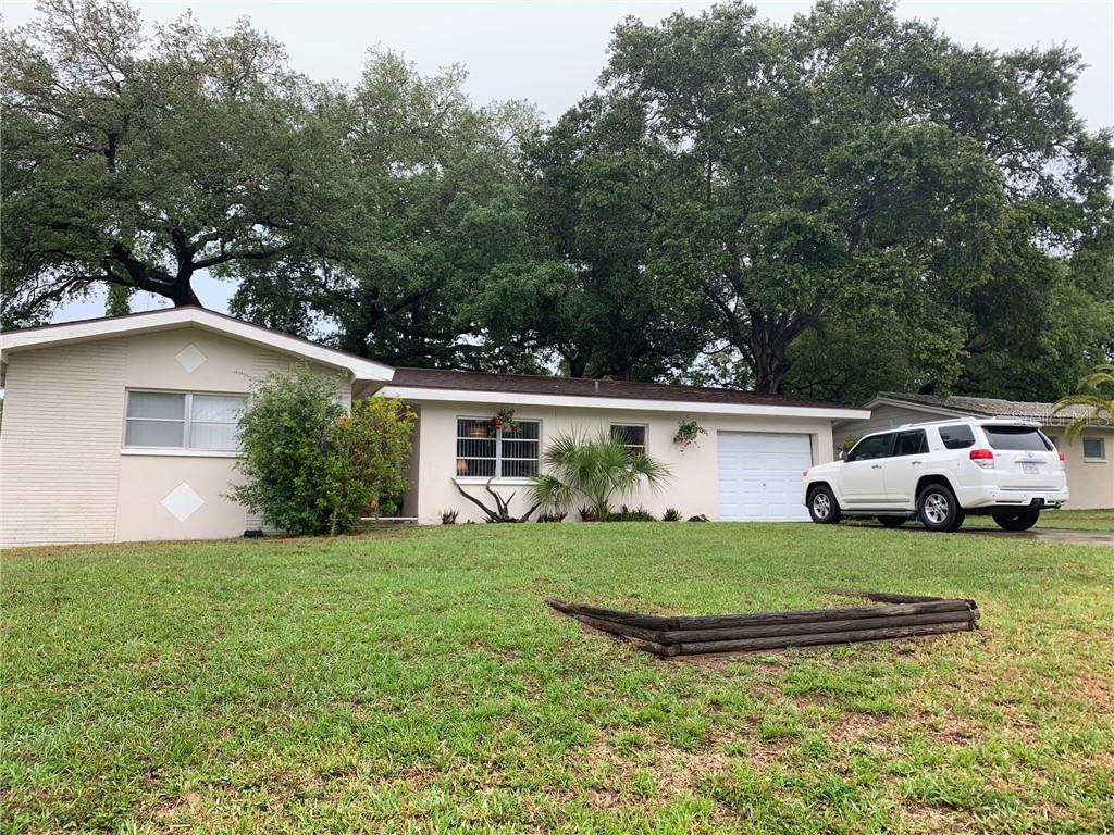 1923 Flora Road Clearwater, FL 33755 - Photo 1 of 1 a view of a house with a big yard and large trees