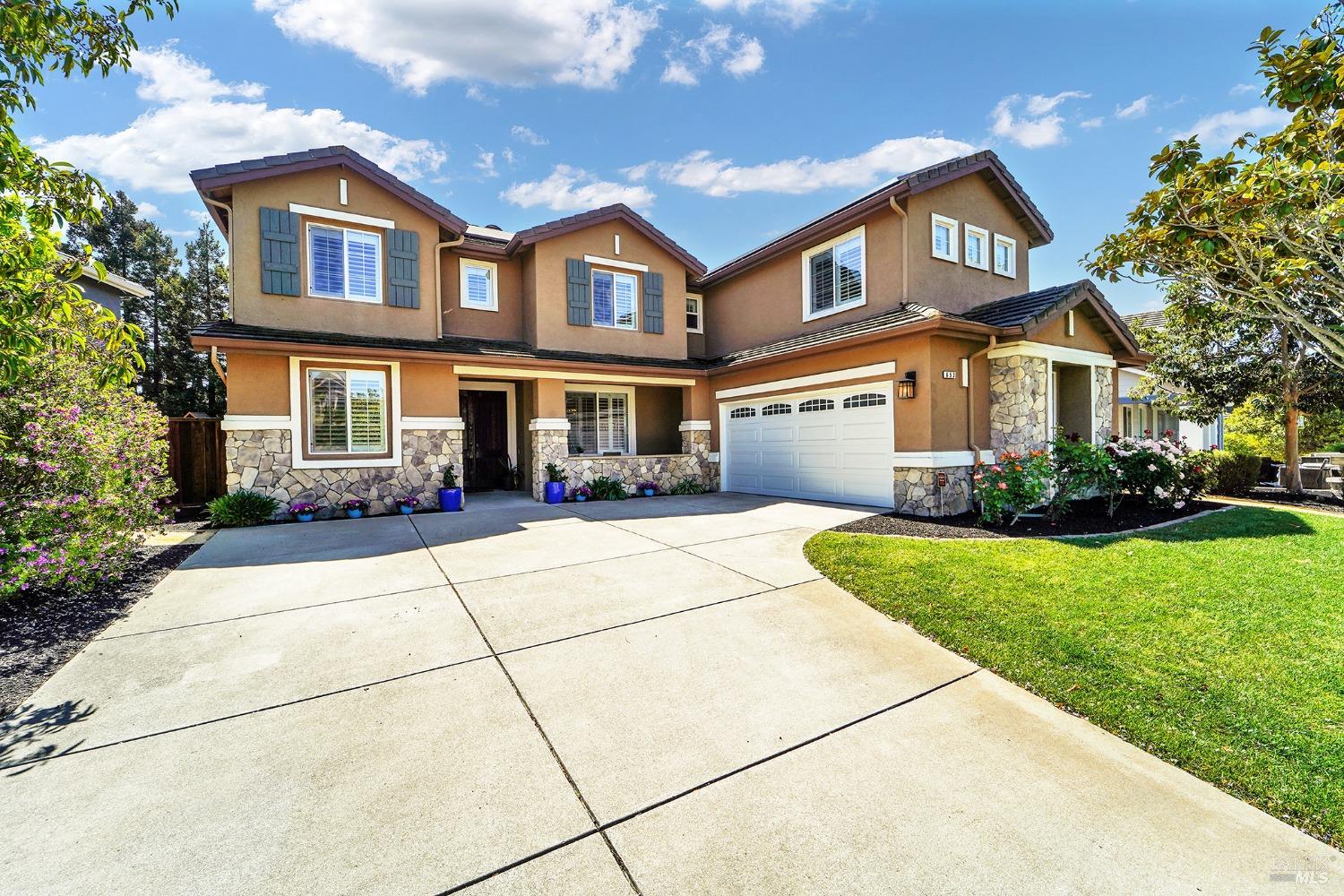 a front view of a house with a yard and trees