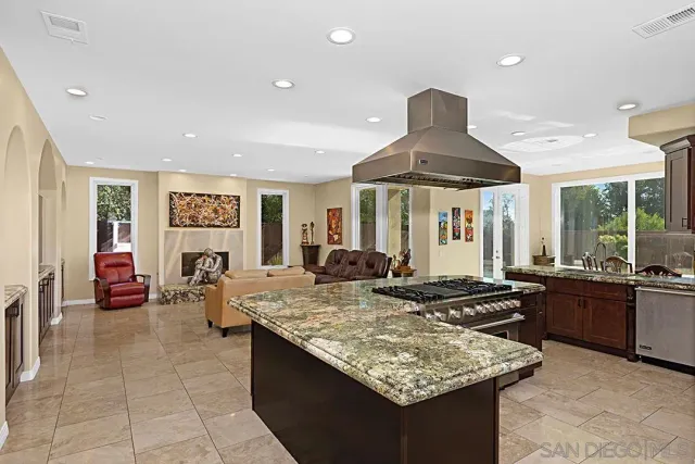 a kitchen with granite countertop a sink stove and refrigerator