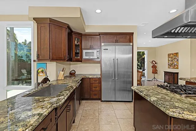 a kitchen with stainless steel appliances granite countertop a stove refrigerator and cabinets
