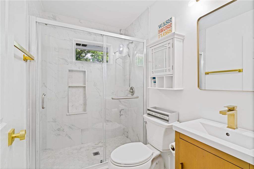 4205 South Berkeley Lake Road Northwest Berkeley Lake, GA 30096 - Photo 22 of 34 a bathroom with a sink toilet and shower