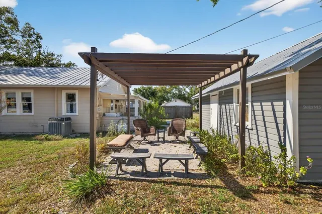 a view of a patio with table and chairs potted plants and floor to ceiling window