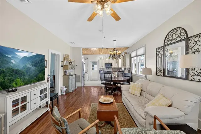 a living room with furniture a flat screen tv and a floor to ceiling window