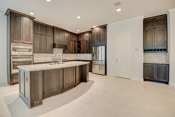 a kitchen with stainless steel appliances a refrigerator and a stove top oven