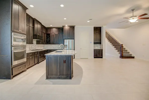 a large kitchen with stainless steel appliances granite countertop a sink and a stove